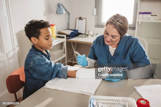 child with arm injury at doctors office - cast of bones stock pictures, royalty-free photos & images