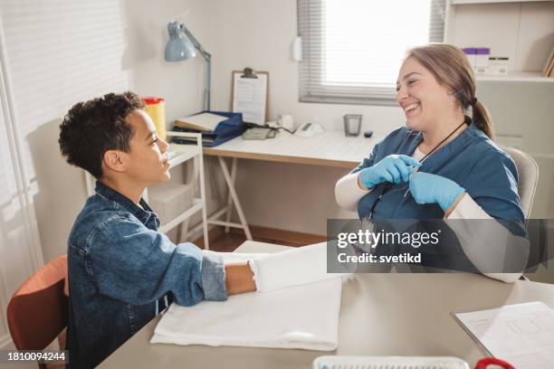 child with arm injury at doctors office - elbow bandage stock pictures, royalty-free photos & images