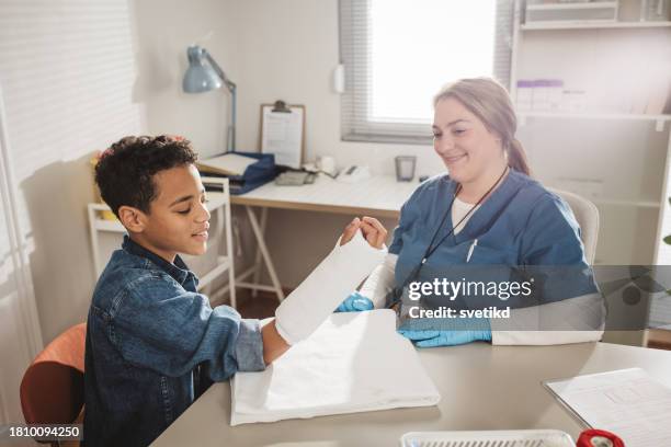 child with arm injury at doctors office - elbow bandage stock pictures, royalty-free photos & images