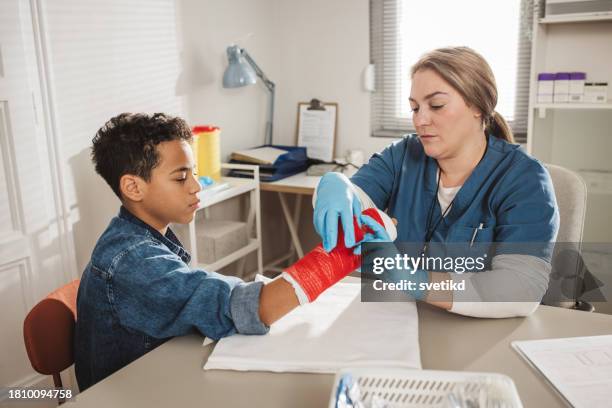 child with arm injury at doctors office - elbow bandage stock pictures, royalty-free photos & images
