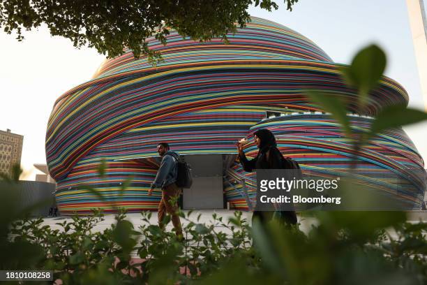 Attendees pass the Russia pavilion in the Blue Zone ahead of the COP28 climate conference at Expo City in Dubai, United Arab Emirates, on Wednesday,...