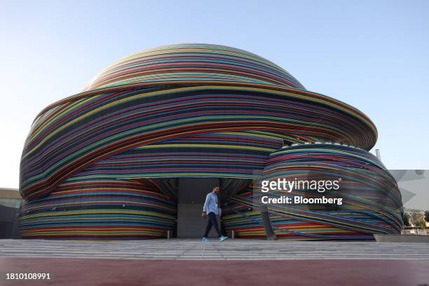 An attendee passes the Russia pavilion in the Blue Zone ahead of the COP28 climate conference at Expo City in Dubai, United Arab Emirates, on...