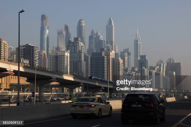 Dubai metro train and automobiles travel past skyscraper buildings in Dubai, United Arab Emirates, on Wednesday, Nov. 29, 2023. More than 70,000...
