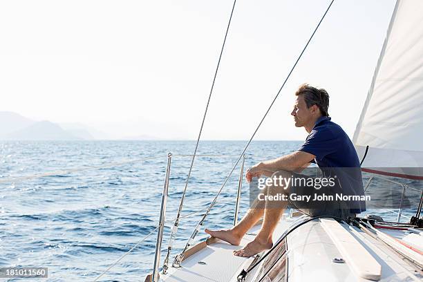 man sitting on bow of sailing yacht - yachting - fotografias e filmes do acervo