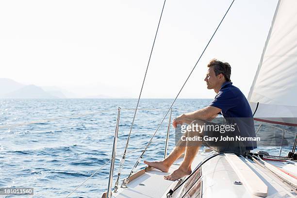 man sitting on bow of sailing yacht - yachting 個照片及圖片檔