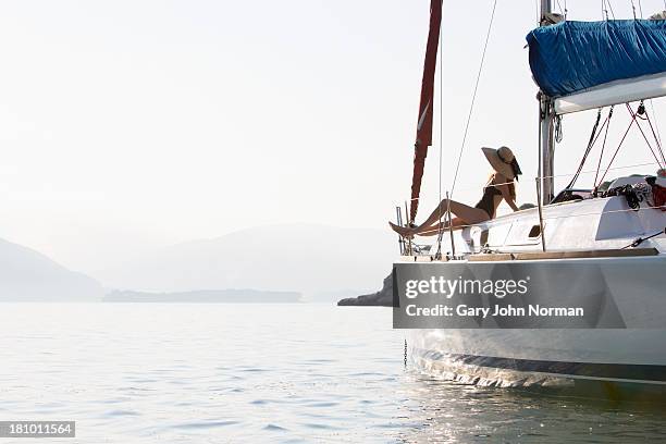 woman in sunhat sits at bow of yacht - yacht bildbanksfoton och bilder