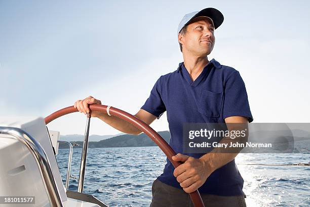 man at hem of sailing yacht - helm nautical vessel part stock pictures, royalty-free photos & images