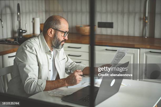 mature adult man working at home - filing documents stock pictures, royalty-free photos & images
