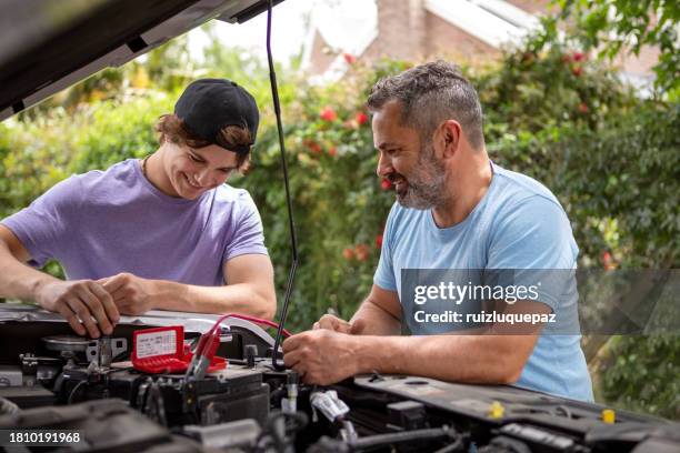 father taught his teenage son how to repair the car - car battery stock pictures, royalty-free photos & images