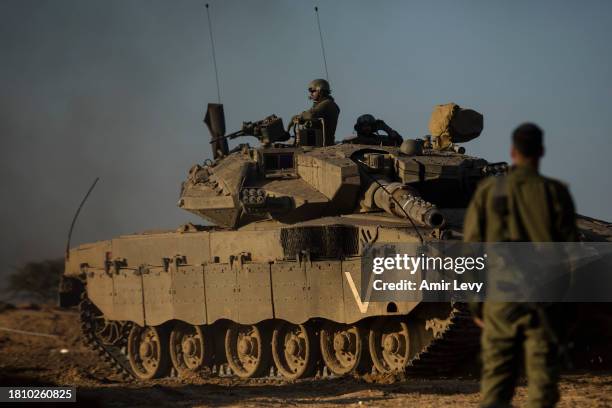 Soldier looks at a tank near the border with the Gaza strip on November 28, 2023 in Southern Border, Israel. Israel and Hamas agreed to a two-day...