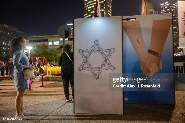 Woman looks at hostage-related artwork outside The Museum of Modern Art known as the 'The Hostages and Missing Square' after it was announced that 13...