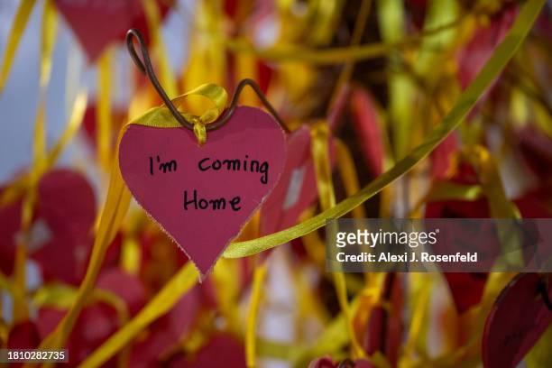 Yellow ribbons and hearts with messages on them hang from a tree outside The Museum of Modern Art known as the 'The Hostages and Missing Square'...
