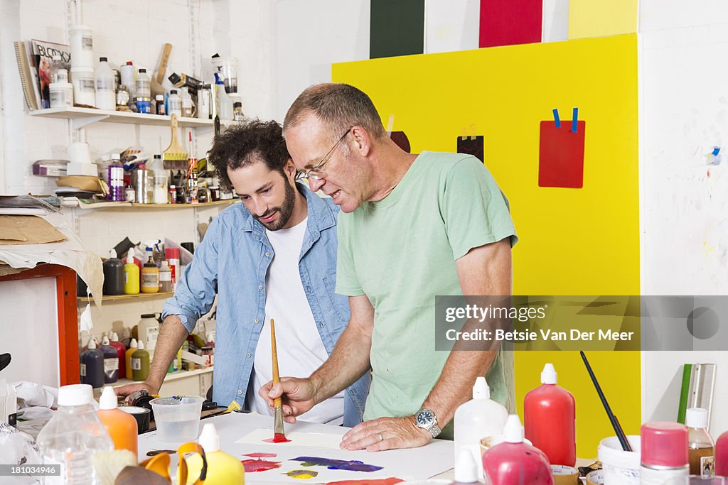 Artist teaching apprentice mixing colours.