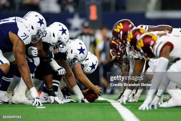 The Dallas Cowboys offensive line lines up across the Washington Commanders defensive line at the line of scrimmage during the first half at AT&T...