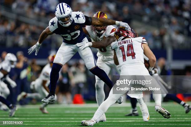 Damone Clark of the Dallas Cowboys hits Sam Howell of the Washington Commanders during the second half at AT&T Stadium on November 23, 2023 in...