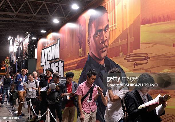 Visitors queue to play the new Rockstar Games videogame "Grand Theft Auto V", which will be released in Japan next month, at the Tokyo Game Show in...