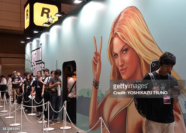 Visitors queue to play the new Rockstar Games videogame "Grand Theft Auto V", which will be released in Japan next month, at the Tokyo Game Show in...