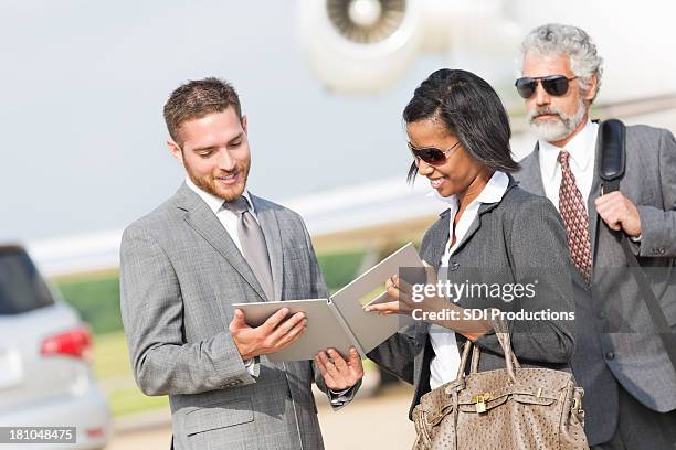 professional business team reviewing contract after private jet flight - elderly receiving paperwork stock pictures, royalty-free photos & images