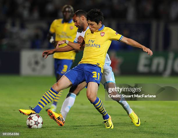 Ryo Miyaichi of Arsenal challenged by Saber Khalifa of Marseille during the match at Stade Velodrome on September 18, 2013 in Marseille, France.