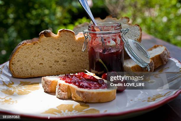 plate with sourdough bread spread with cherry jelly - preserves stock pictures, royalty-free photos & images