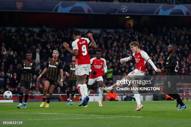 Arsenal's Norwegian midfielder Martin Odegaard scores his team's fifth goal during the UEFA Champions League Group B football match between Arsenal...