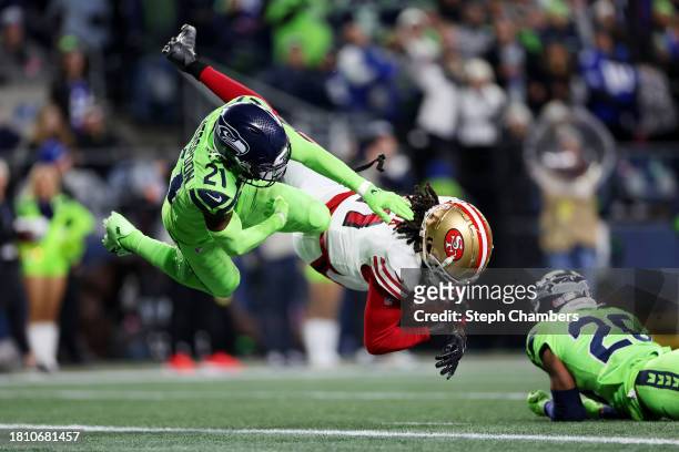 Brandon Aiyuk of the San Francisco 49ers scores a touchdown as Devon Witherspoon of the Seattle Seahawks defends during the fourth quarter at Lumen...
