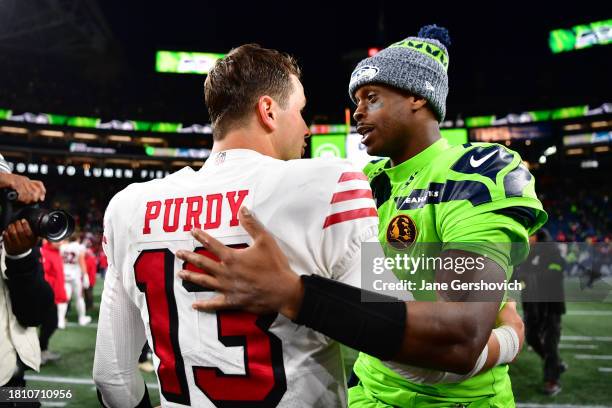 Brock Purdy of the San Francisco 49ers and Geno Smith of the Seattle Seahawks meet at midfield after the game at Lumen Field on November 23, 2023 in...