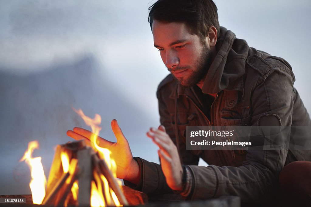 Warming himself at the flames