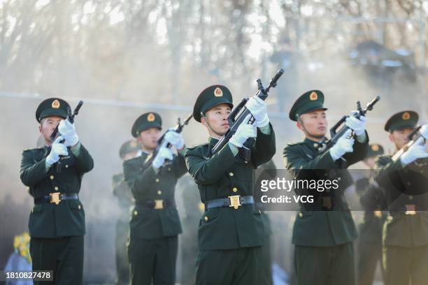 Chinese honour guards fire a gun salute during a burial ceremony for the remains of 25 Chinese soldiers who died during the Korean War at the Chinese...