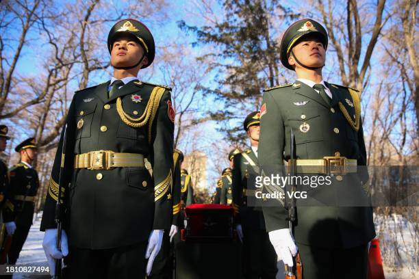 Chinese honour guards carry coffins containing remains of 25 Chinese soldiers who died during the Korean War during a burial ceremony at the Chinese...