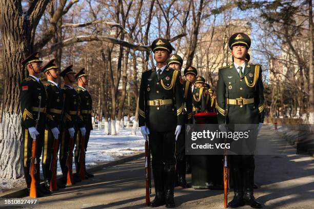 Chinese honour guards carry coffins containing remains of 25 Chinese soldiers who died during the Korean War during a burial ceremony at the Chinese...