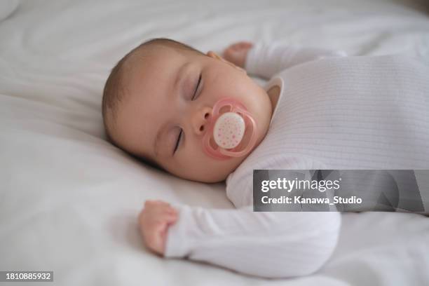 baby girl sleeping with pacifier on her mouth - babys dummy stock pictures, royalty-free photos & images