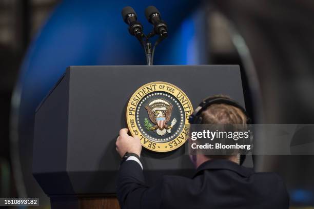 Worker attaches the presidential seal to a podium before US President Joe Biden speaks during an event at CS Wind in Pueblo, Colorado, US, on...