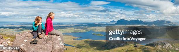 young hikers looking out over dramatic mountain wilderness panorama - scotland mountains stock pictures, royalty-free photos & images