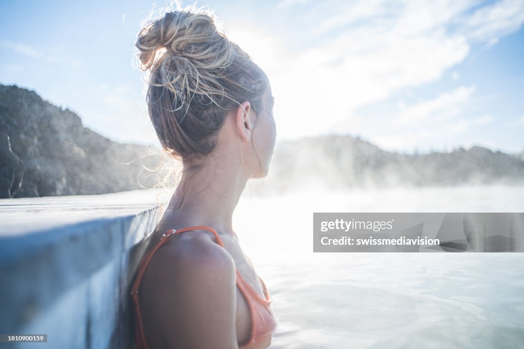 Woman relaxes in outdoor hot bath