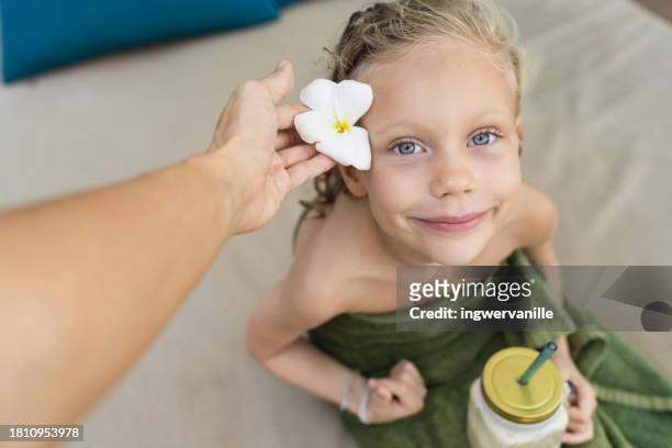 close-up of smiling girl with flower in the hair drinking smoothie at the beach - smoothie close up textfreiraum stock-fotos und bilder