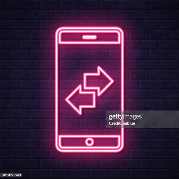 transfer with smartphone. glowing neon icon on brick wall background - touch screen wall stock illustrations