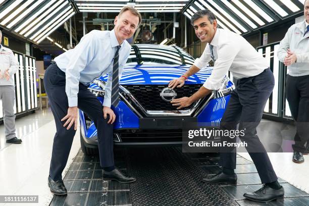 Prime Minister Rishi Sunak and Chancellor of the Exchequer Jeremy Hunt attach a Nissan badge to a car as they visit the car manufacturer Nissan on...