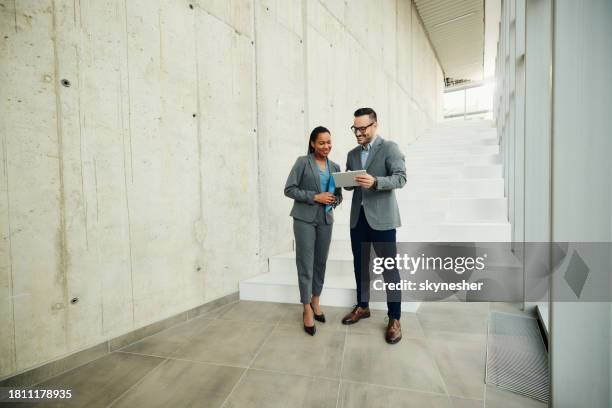 happy business colleagues working on touchpad in a hallway. - two people standing stock pictures, royalty-free photos & images