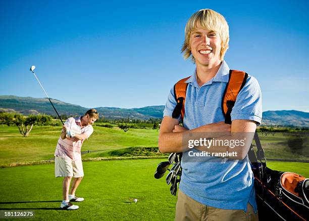 father and son golfing - golf caddy stockfoto's en -beelden