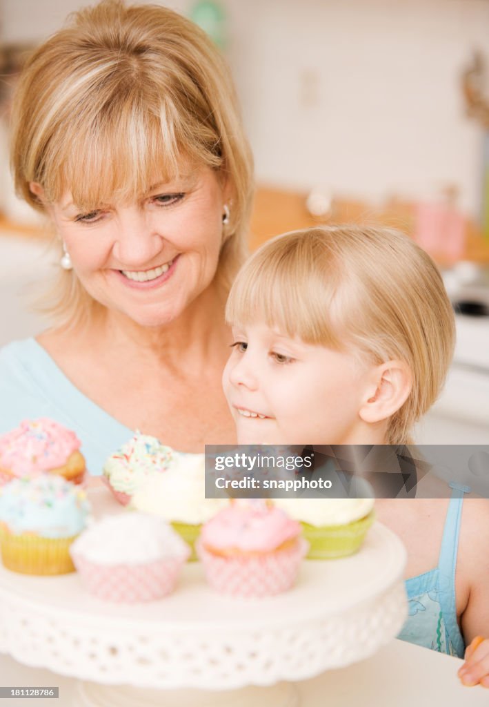 Kinder und Ältere Dame isst Cupcakes