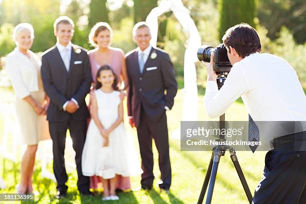 mann fotografieren familie bei hochzeit im freien - photographer stock-fotos und bilder