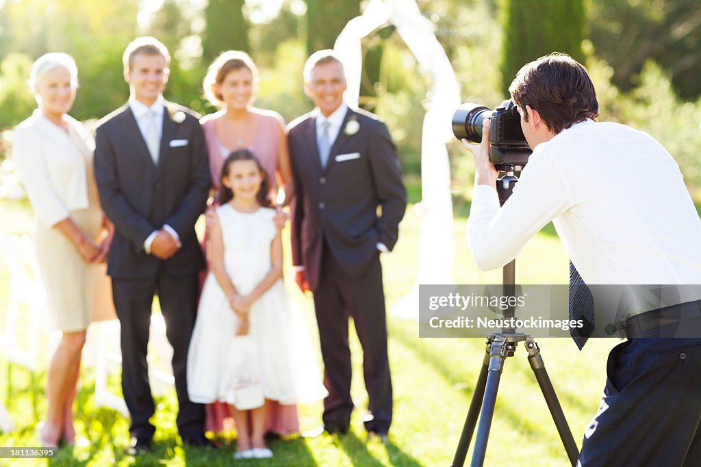 Hombre tomando familiar en boda al aire libre