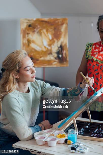 woman painting the canvas - oil pastel drawing stock pictures, royalty-free photos & images