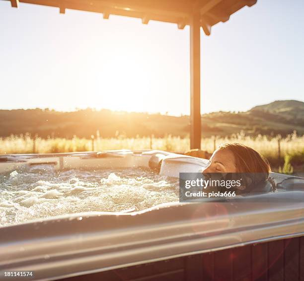 femme dans un bain à remous jacuzzi - bain à remous photos et images de collection