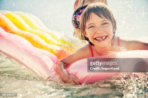 little girl having fun in sea - spleetje stockfoto's en -beelden
