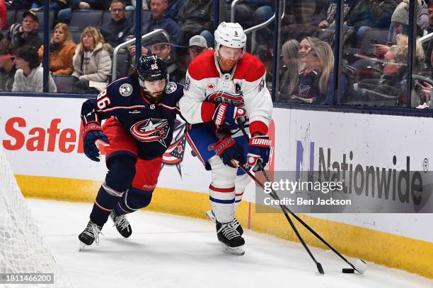 Kirill Marchenko of the Columbus Blue Jackets and Mike Matheson of the Montreal Canadiens battle for the puck during the first period of a game at...