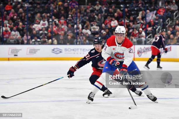 Kaiden Guhle of the Montreal Canadiens skates with the puck as Alexandre Texier of the Columbus Blue Jackets defends during the first period of a...