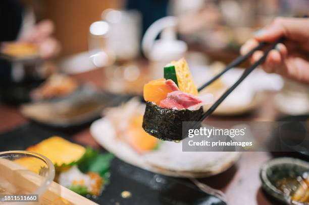 groupe d’amis dînant des sushis à la bière izakaya style japonais dans un restaurant japonais - cuisine japonaise photos et images de collection