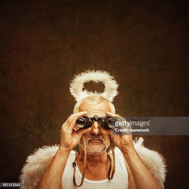 senior angel using binocular - touched by an angel stockfoto's en -beelden